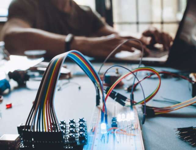 Schmuckbild Student, der in an einem elektronischen Versuchsaufbau arbeitet