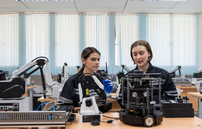 Team female engineers training Programmable logic controller with AI robot and Artificial Intelligence of Things service robot in the laboratory room