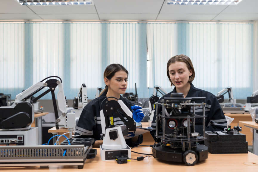 Team female engineers training Programmable logic controller with AI robot and Artificial Intelligence of Things service robot in the laboratory room