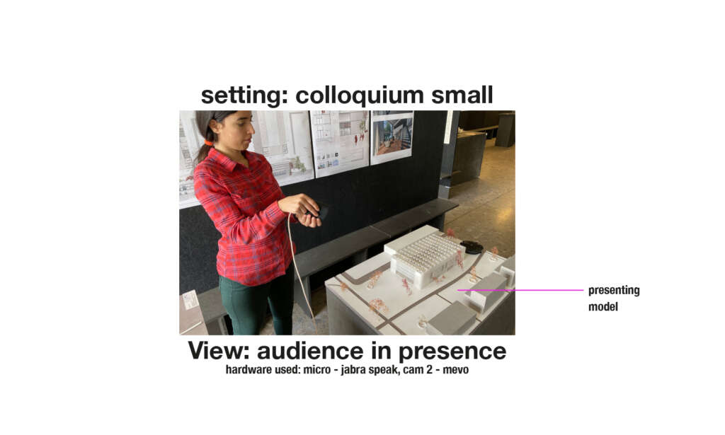 Setting: kleines Kolloquiuum, Ansicht des in Präsenz anwesenden Publikums, eine Person steht neben einem Modell von einem Gebäude. Verwendete technische Ausstattung: Jabra Speak Mikrofon, Kamera mevo.
